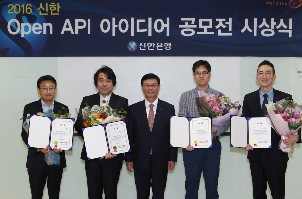 지난 20일 서울 중구 소재 신한은행 본점에서 진행된 ‘2016 신한 Open API 아이디어 공모전’ 시상식에서 신한은행 유동욱 부행장(왼쪽에서 세번째)과 수상자들이 기념촬영 하는 모습 / 사진=신한은행