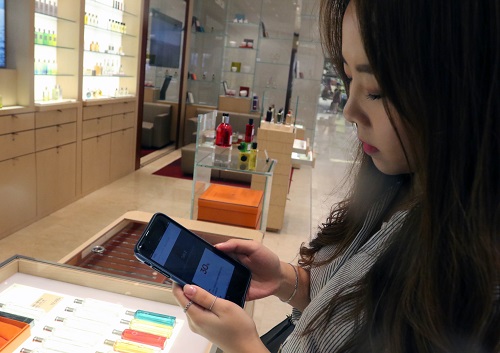한 소비자가 신세계백화점에서 모바일 프로모션 정보를 통해 쇼핑을 하고 있다. 신세계백화점 제공 
