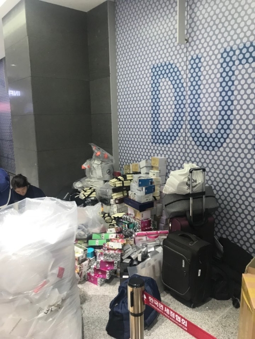 18일 인천국제공항 제2여객터미널(T2) 면세품 인도장에서 중국 보따리상이 캐리어에 제품을 담고 있다. 신미진기자 