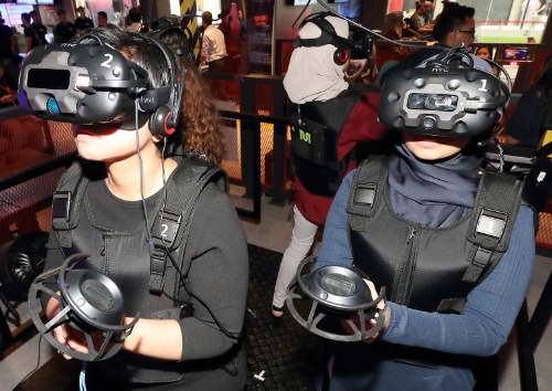 ▲ 말레이시아 VR 테마파크 ‘브리니티’에서 현지 고객들이 VR 어트랙션과 게임을 체험하고 있다. /사진=KT