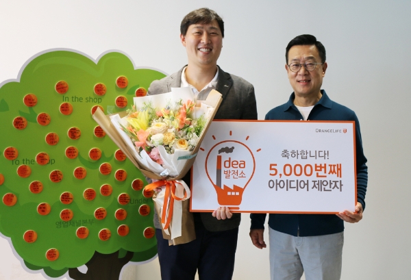 서울 중구 순화동 오렌지센터에서 5000번째 아이디어를 제안한 오렌지라이프 직원과 정문국 사장(오른쪽)이 기념촬영을 하고 있다. / 사진 = 오렌지라이프