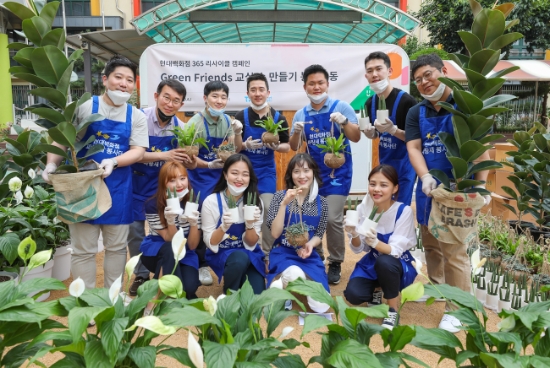 지난 18일 서울 매봉초등학교에서 현대백화점 직원들이 공기정화식물과 함께 기념 촬영을 하고 있다. / 사진 = 현대백화점
