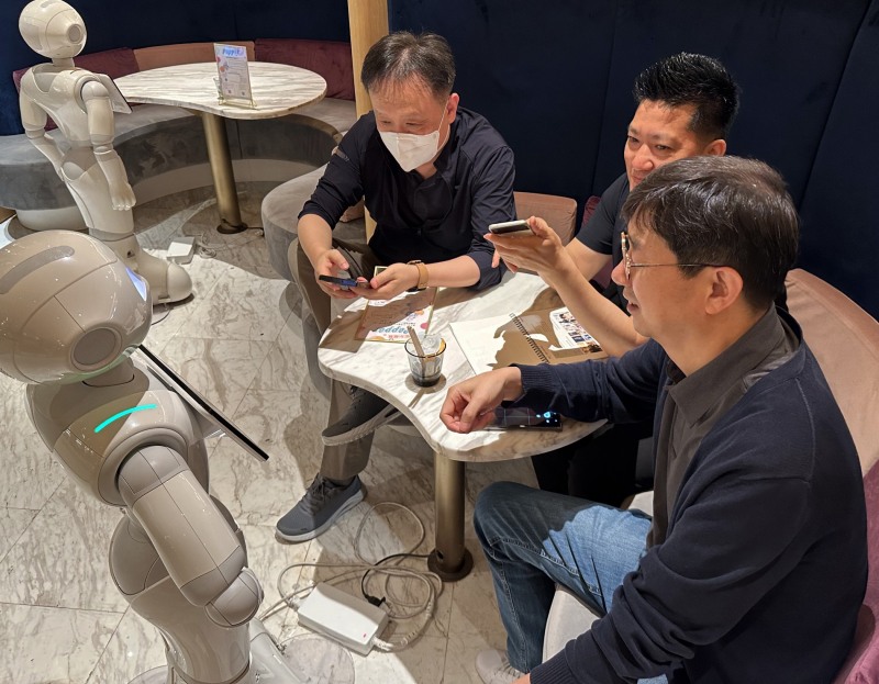 프로그램에 참여한 직원들이 일본 도쿄의 PEPPER PARLOR 카페에서 서비스 로봇 이용을 체험하고 있다. 사진 제공=LG유플러스