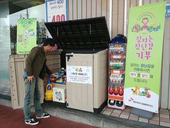 동탄드림주유소를 찾은 고객이 집에서 쓰지 않는 장난감을 기부하고 있다. 출처 : SK이노베이션.