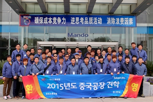 만도의 중국 쑤저우 생산 법인인에서 기능직 직원들이 생산현장 견학 후 기념사진을 찍고있다. 만도 제공