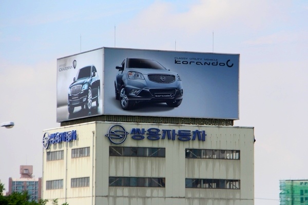 경부고속국도 경기도 구간 인근에 위치한 쌍용차 대리점의 코란도 C 홍보물. 정수남 기자
