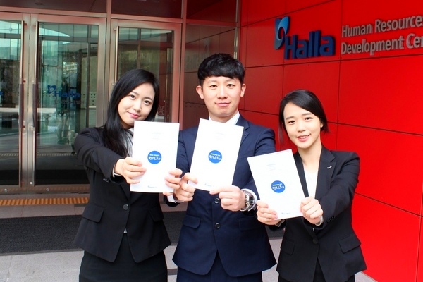 한라그룹 신입사원들이 한라인재개발원에서 새로 발간된 ‘제대로 일하는 방식 한라로(路)’ 소책자를 들어 보이고 있다. 한라그룹 제공