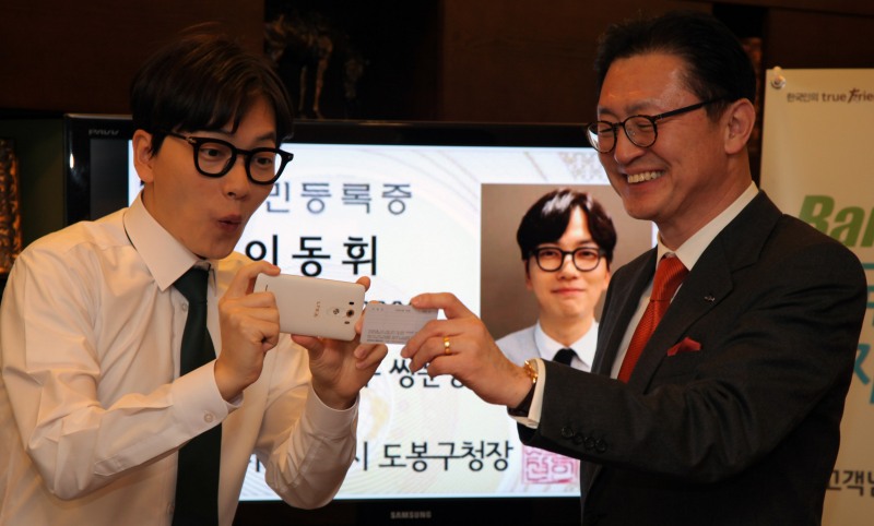 한국투자증권 유상호 사장(오른쪽)과 한국투자증권 뱅키스 모델 방송인 이동휘씨가 모바일 금융거래 앱 펀답(FundApp)을 통한 비대면 실명확인 계좌서비스를 선보이고 있다.(사진=한국투자증권)