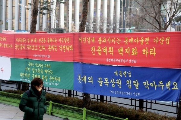 지난달 29일 문을 연 롯데아웃렛 가산점이 현지 아웃렛 시장 확대에 기여할 것으로 보이지만, 금천패션아웃렛단지연합회 측은 현재 서울 중구 롯데백화점 본점 앞에 현수막을 걸고 입점을 비난하고 있다. 정수남 기자