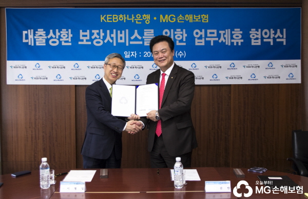 △사진설명:권순만 MG손해보험 전무(오른쪽)가 이형일 KEB하나은행 전무와 악수를 나누고 있다.