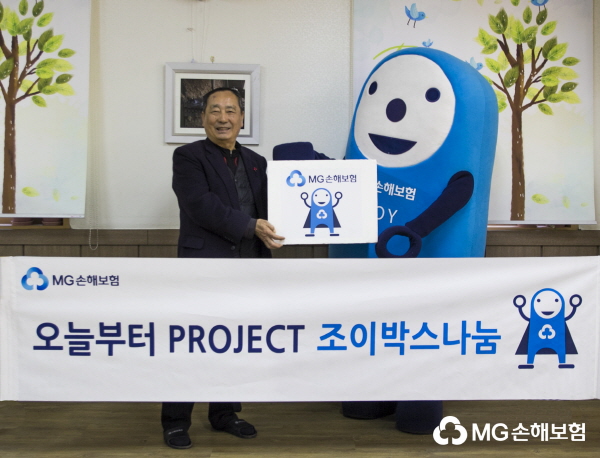 △사진설명=부청하 상록보육원장(왼쪽)에게 학용품 조이박스를 전달하는 MG손해보험 조이(JOY)의 모습.
