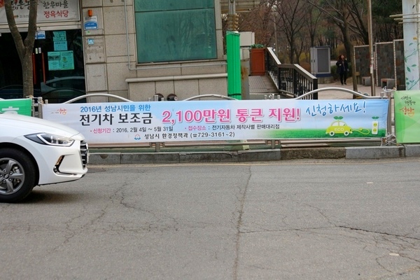 정부와 지자체가 전기자 보급에 주력하고 있다. 사진은 전기차 구매 혜택을 알리는 성남시가 설치한 현수막. 정수남 기자