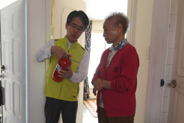 △이윤배 NH농협손해보험 대표이사(왼쪽)가 서울시 서대문구 내 저소득층가구를 방문, 어르신께 소화기 사용법을 설명하고 있다./사진제공=농협손보