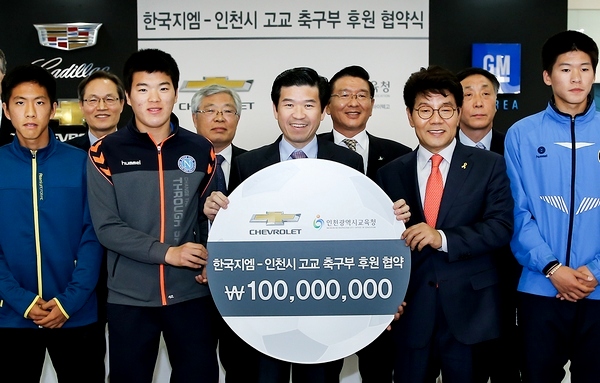 제임스 김 한국GM 사장(앞줄 가운데)이 이청연 인천광역시 교육감(앞줄 오른쪽) 인천 지역 5개 고등학교 학교장과 축구팀 감독, 대표 선수들과 함께 기념 사진을 찍고있다.