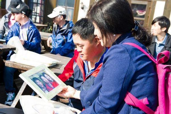 장애인 사우와 어머니가 쁘띠프랑스에서 찍은 가족사진을 보고있다, 현대오일뱅크 제공