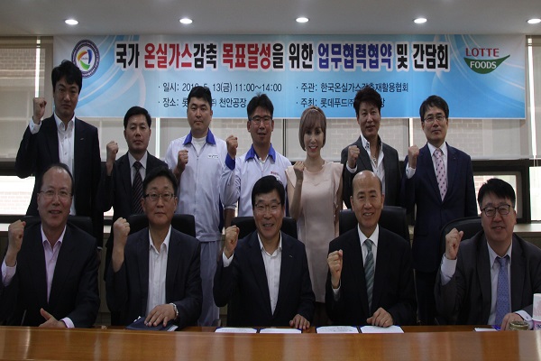 13일 롯데푸드 김종길 생산본부장(가운데)과 한국온실가스감축재활용협회 이만의 회장(우측 두번째)이 온실가스 감축을 위한 업무협력 협약을 체결하고 있다. 롯데푸드 제공