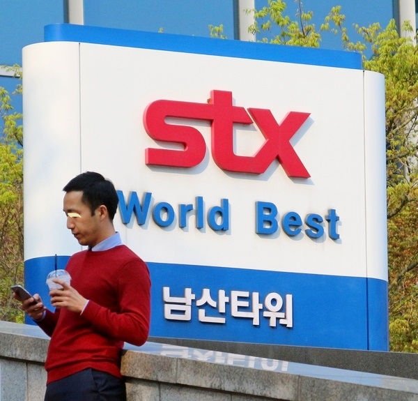 STX조선해양의 서울 남산타워에서 이 회사 한 직원이 무거운 표정으로 스마트폰을 보고있다. 정수남 기자