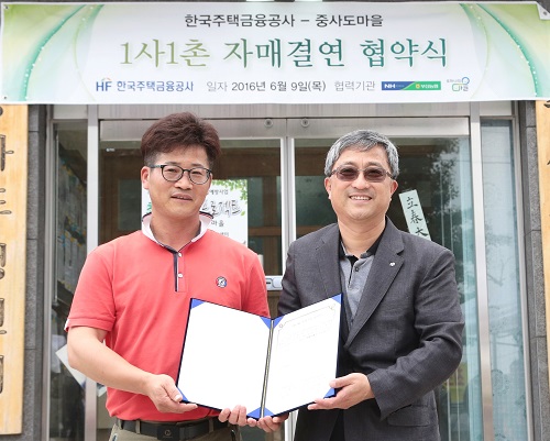 △김태원 중사도마을 이장(왼쪽)과 유상규 주택금융공사 이사가 협약식 후 기념촬영을 하고있다./사진제공=주택금융공사