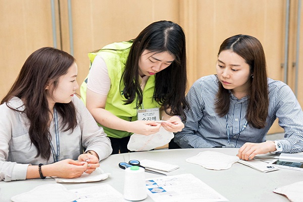 올리브영 임직원 봉사단이 서울시자원봉사센터 소속 봉사 단원에게 면생리대를 만드는 법을 배우고 있다.CJ올리브네트웍스 제공 