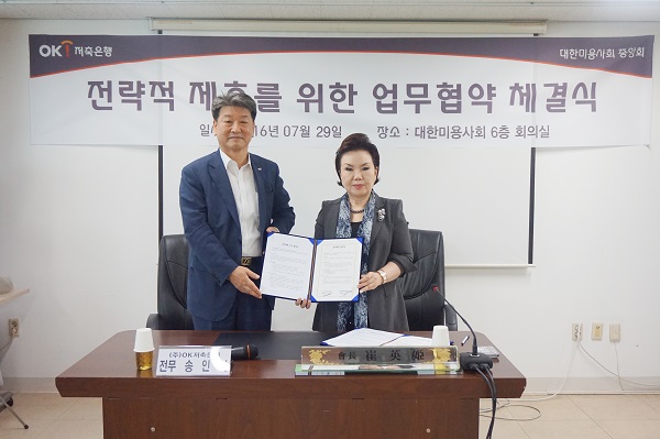 △송인석 OK저축은행 전무(왼쪽)와 최영희 대한미용사회중앙회 회장이 협약식 후 기념촬영을 하고 있다./사진제공=OK저축은행