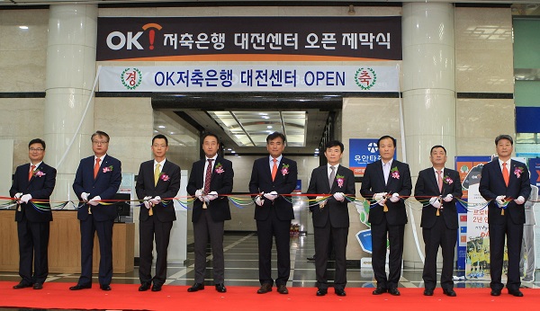 △정길호 OK저축은행 대표이사(가운데)와 이현주 대전광역시 정무부시장(정길호 대표이사 오른쪽)이 제막식에 참여하고 있다./사진제공=OK저축은행