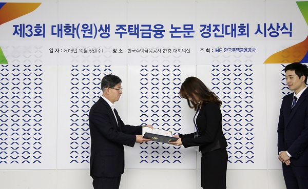 △김재천 주택금융공사 사장(왼쪽)이 부산 남구 문현금융로에 위치한 주택금융공사 본사에서 ‘제3회 대학(원)생 주택금융 논문 경진대회’ 수상자에게 시상을 하고 있다./사진제공=주택금융공사