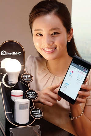 ▲ 서울 영등포구 여의대로 LG 트윈타워에서 모델이 스마트 전구, 스마트 플러그, 모션센서 등 사물인터넷 연동기기 3종을 소개하고 있다. LG전자 제공