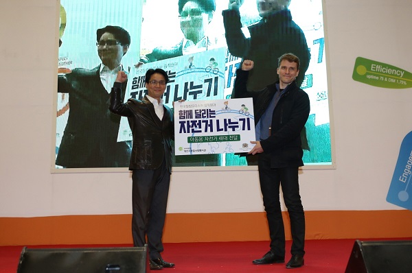 한국필립모리스가 2일 부산 벡스코에서 ‘함께 달리는 자전거 나누기’ 행사를 가진 가운데 한국필립모리스 양산 공장 미샤 프로코프축 공장장(우)과 양산시종합사회복지관 황은일 부장(좌)이 자전거 전달식을 진행하고 있다. 한국필립모리스 제공