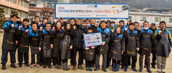 △아주저축은행 임직원들이 연탄 나눔 봉사 후 기념촬영을 하고 있다./사진제공=아주저축은행