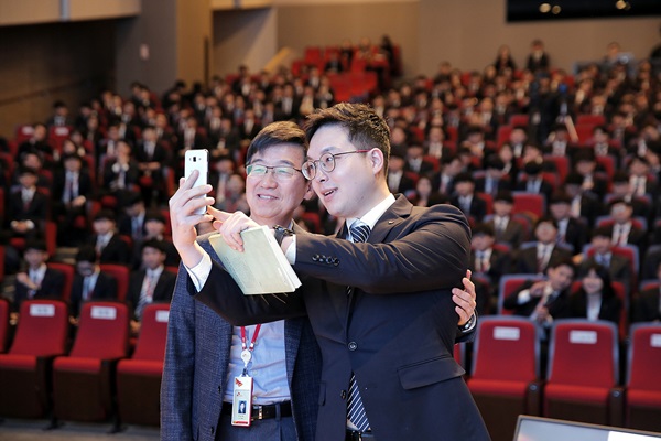 박성욱 SK하이닉스 부회장이 신입사원에게 도움이 될 수 있는 추천도서를 선물한 뒤 함께 기념사진을 촬영하고 있다.