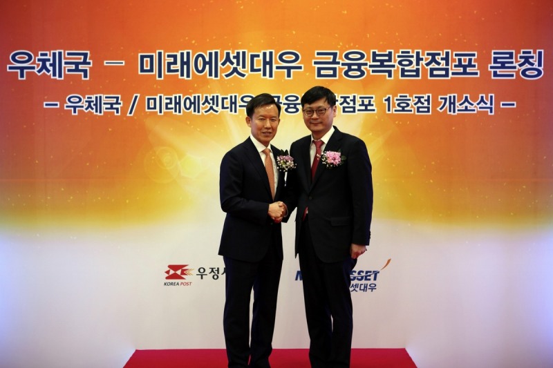 미래에셋대우 대표이사 최현만 수석부회장(왼쪽)과 우정사업본부 정진용 예금사업단장이 13일 미래에셋대우-서울중앙우체국 금융복합점포 개점기념 촬영을 하고 있다.