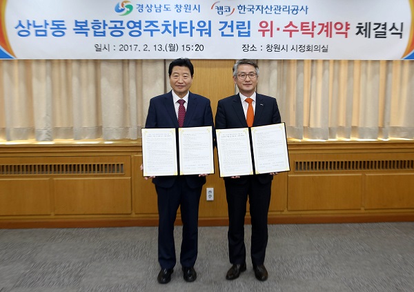 △문창용 캠코 사장(오른쪽)이 창원시청에서 안상수 창원시장(왼쪽)과 상남동 복합공영주차타워 건립에 관한 위수탁계약을 체결하고 기념촬영을 하고 있다./사진제공=캠코