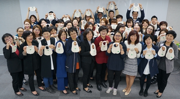△직접 만든 턱받이를 들고 환하게 웃고 있는 흥국생명 설계사들/ 사진제공=흥국생명