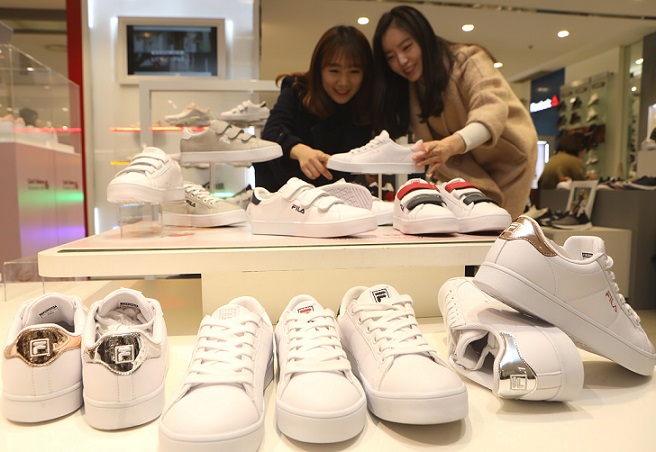 ▲ 최근 롯데백화점 본점을 찾은 소비자들이 스포츠화 매장에서 고객이 코트화 고르는 모습. (사진=롯데백화점)