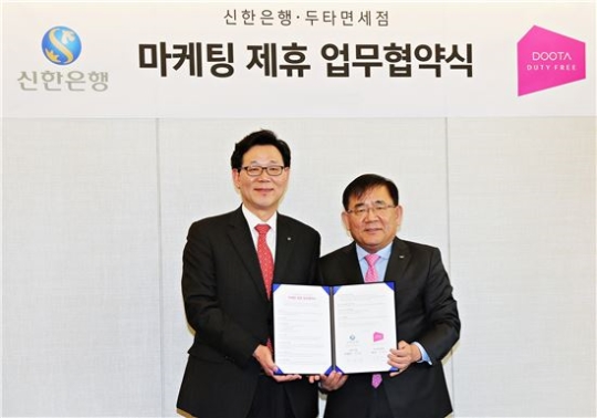 두타면세점 조용만 BG장(우)과 신한은행 최병화 부행장은 9일 오후 동대문 두산타워에서 국내외 고객을 위한 마케팅 활동에 상호 협력하는 내용의 업무제휴를 체결했다.