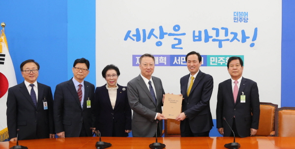 박용만 대한상공회의소 회장(사진 왼쪽에서 4번째)이 23일 더불어민주당 우상호 원내대표(사진 왼쪽에서 5번째)를 만나 제언문을 전달하고 있다.