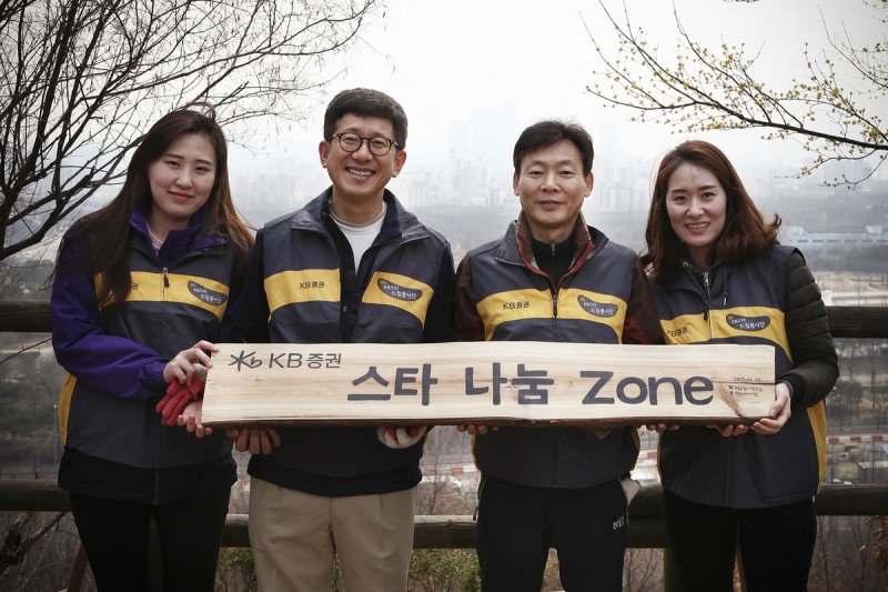 KB증권은 지난 25일 서울 상암동 노을공원에서 'KB증권 스타나눔 ZONE 숲'을 조성한 후 이재형 WM총괄본부장(왼쪽에서 두번째)와 김재봉 디지털고객본부장(왼쪽에서 세번째)이 직원들과 나무 팻말을 들며 기념촬영을 하고 있다.