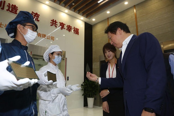 △ 최태원 SK그룹 회장(사진 오른쪽)이 지난 2016년 9월 하이닉스 충칭 공장을 방문, 후공정을 통해 생산중인 반도체 제품을 살펴보고 있다.