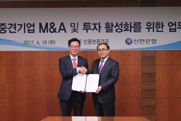 △박학양 신용보증기금 이사(오른쪽)와 최병화 신한은행 부행장이 18일 신한은행 본점에서 ‘중소 · 중견기업 M&A 및 투자 활성화’를 위한 업무협약을 체결하고 기념촬영을 하고 있다./사진제공=신용보증기금