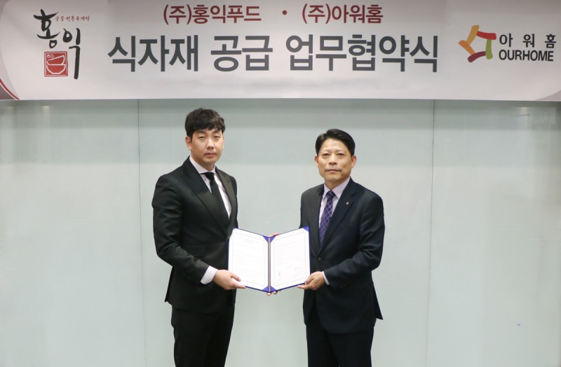 (좌측부터) 27일 임현광 홍익푸드 이사와 이종상 아워홈 식자재사업부장이 식자재 공급 업무협약식을 체결하고 기념촬영을 하고 있다. 아워홈 제공