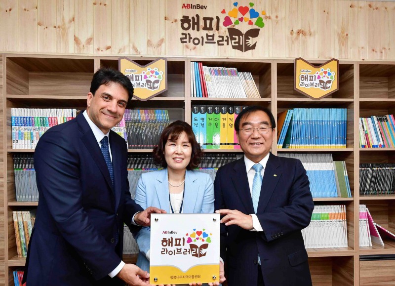 (좌측부터) 4일 충북 청주시 행복나무지역아동센터에서 열린 오비맥주 ‘해피 라이브러리’ 완공 기념식에서 김도훈 오비맥주 사장과 신희경 행복나무지역아동센터장, 이승훈 청주시장이 기념 촬영을 하고 있다. 오비맥주 제공