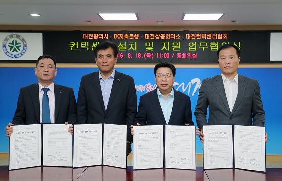 △2016년 8월 18일에 정길호 OK저축은행 대표(왼쪽에서 두번째)가 대전광역시와 컨택센터 설치및 지원에 관한 업무 협약 후 기념촬영을 하고 있다./사진제공=OK저축은행