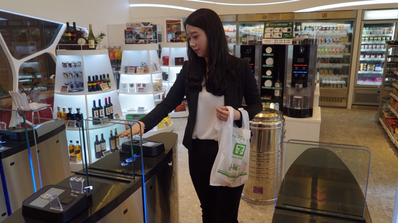 서울 잠실 롯데월드타워 31층에 위치한 ‘세븐일레븐 시그니처’에서 롯데 관계자가 정맥인증 결제시스템‘핸드페이’시범을 보이고 있다. 코리아세븐 제공