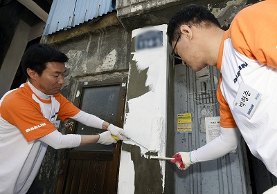 △ 김한기 대림산업 사장(좌측)이 외벽을 페인트로 칠하고 있다. /사진제공=대림산업