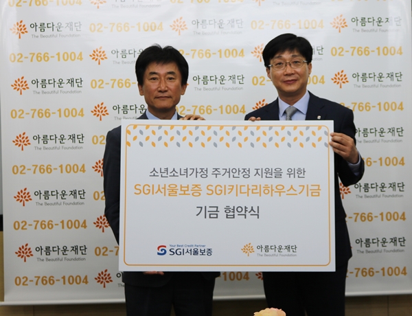 △24일 이득영 SGI서울보증 상무(우측)가 아름다운재단 박종문 이사장에게 기부금을 전달했다.