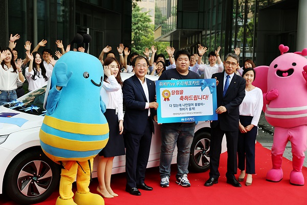 △우리카드 본사 앞에서 지난 28일 ‘위비 Five 체크카드’이벤트 1등 당첨자 경품 증정식을 진행하고 있다./사진제공=우리카드