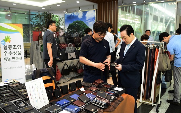 △신종백 새마을금고중앙회장 겸 한국협동조합협의회장이 삼성동 본부 회관에서 한국가죽산업협동조합 상품에 대한 설명을 듣고 있다./사진제공=새마을금고중앙회