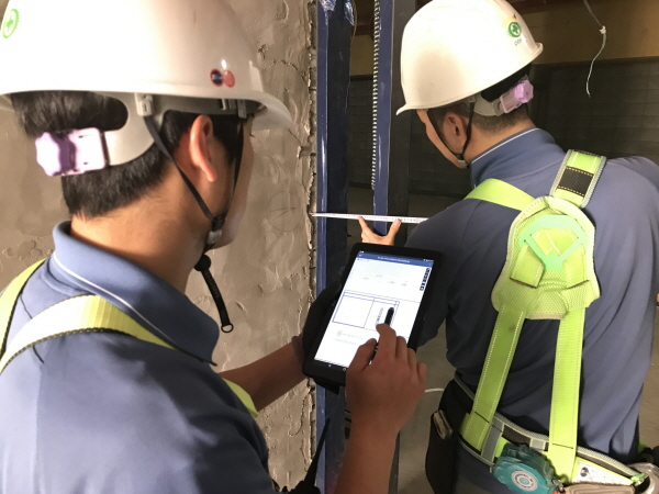 △ 포스코건설 송도국제도시 건설현장 소장이 태블릿 PC로 설계도면을 확인하며 수정사항을 지시하고 있다. 사진=포스코건설.