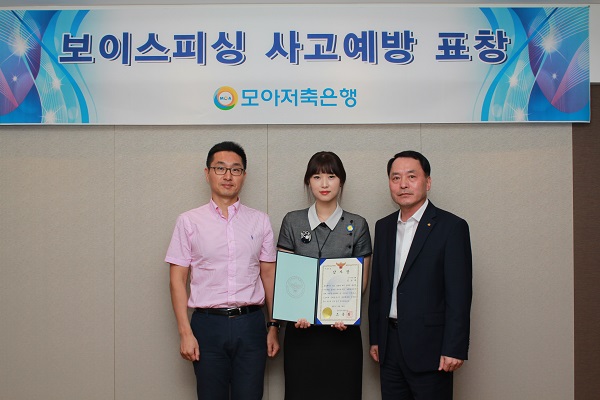 △모아저축은행 직원이 보이스피싱 예방 공로로 인천 남부경찰서로부터 감사장을 받고 기념촬영을 하고 있다./사진=모아저축은행