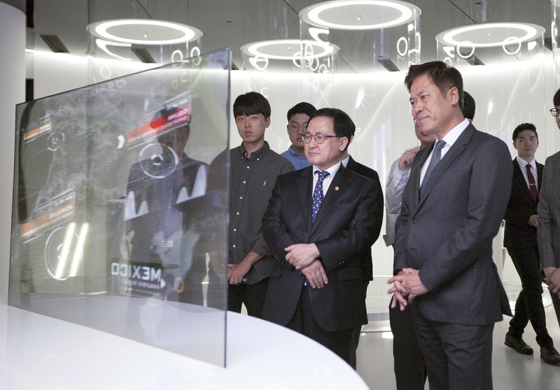 △티움 미래관에서 투명 OLED TV를 들여다보며 지구 환경 모니터링 체험을 하고 있는 유영민 과학기술정보통신부장관(앞줄 왼쪽)과 박정호 SK텔레콤 사장(앞줄 오른쪽) /사진제공=SK텔레콤